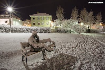 Veistos, joka esittää penkillä istuvaa miestä eräässä puistossa Reykjavikissa.