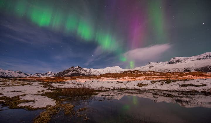 Travel in Iceland during winter time and witness the northern lights dancing in the sky above you.