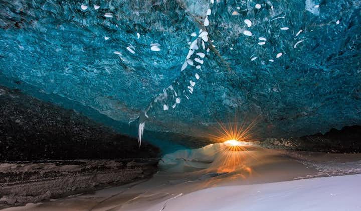แสงอาทิตย์ในฤดูหนาวส่องผ่านโลกที่สวยงามของถ้ำน้ำแข็งที่สวยงามแห่งหนึ่งในวัทนาโจกุล