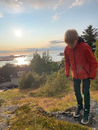 A kid on top of Hamarinn with Hafnarfjordur and the sea on the background