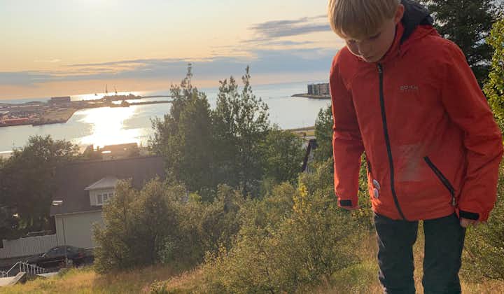 A kid on top of Hamarinn with Hafnarfjordur and the sea on the background