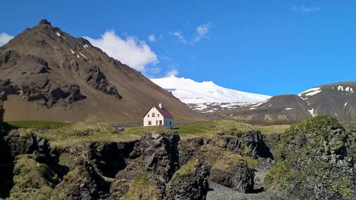 The magnificent Snæfellsjökull rises over an old farm and lava field on the tip of West Iceland's Snæfellsnes Peninsula.