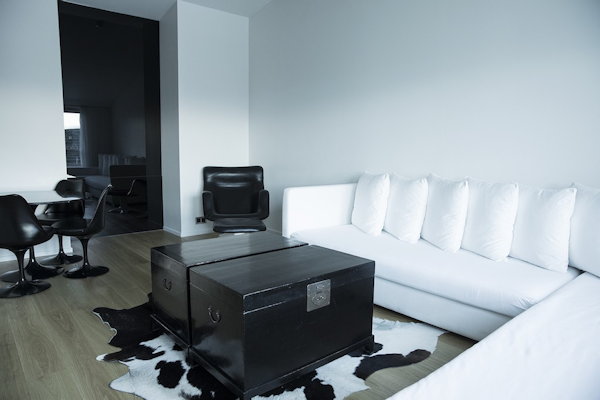 A spacious suite with a sofa and comfortable corner chair at 101 Hotel Reykjavik.