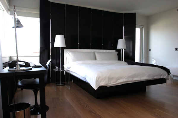 A queen-sized bed, desk, chair, and bedside lamps in a room at 101 Hotel Reykjavik.