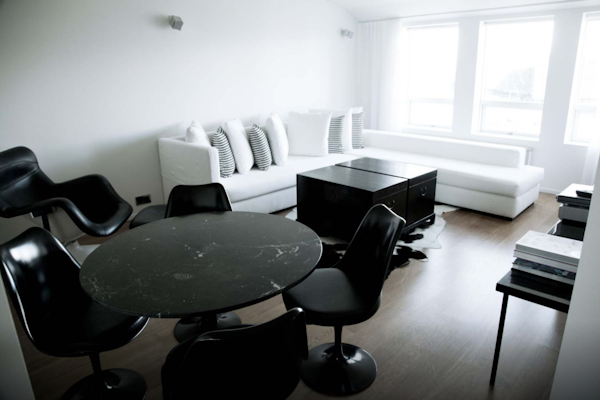 A spacious suite with a table, chairs, and sofa at 101 Hotel Reykjavik.