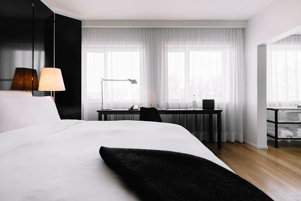 A bed, desk, and chair in a minimalist-style room at 101 Hotel Reykjavik.