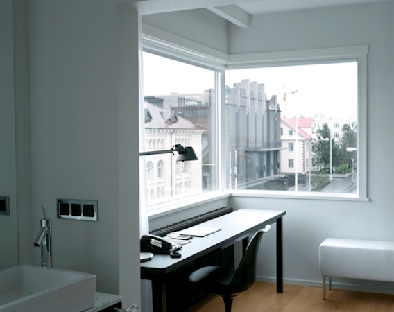 A desk and chair in front of the window with street views at 101 Hotel Reykjavik.