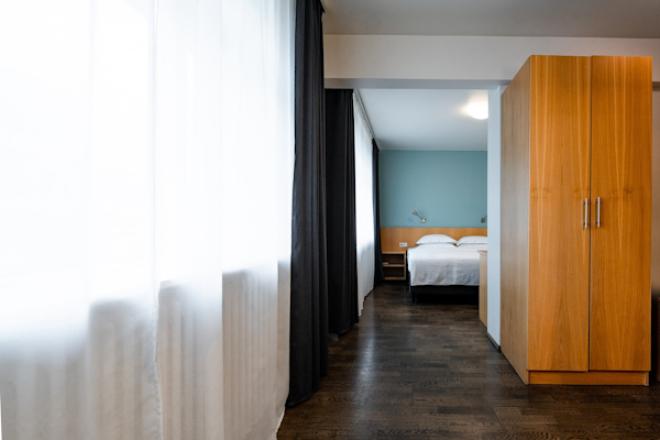 A corridor and bed in one of the rooms at Center Hotels Klopp in Reykjavik.