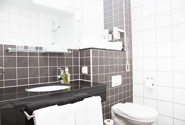 A bathroom at Center Hotels Arnarhvoll with practical amenities like a towel and hair dryer.