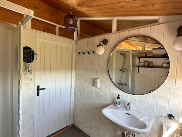 A sink with a mirror above it in the bathroom at Hestaland Horse Farm Cottage.