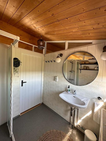 A sink with a mirror above it in the bathroom at Hestaland Horse Farm Cottage.