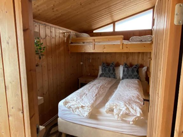 A double bed with a single bed over the top of it in one of the rooms at Hestaland Horse Farm Cottage.