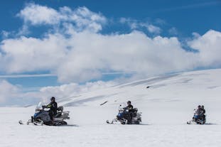 Leave your worries behind in the snow dust when riding a snowmobile on Langjökull Glacier in Iceland.