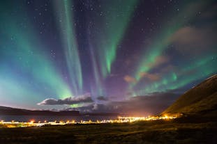蓝色、粉色的北极光降落在冰岛西峡湾的纯净夜空。