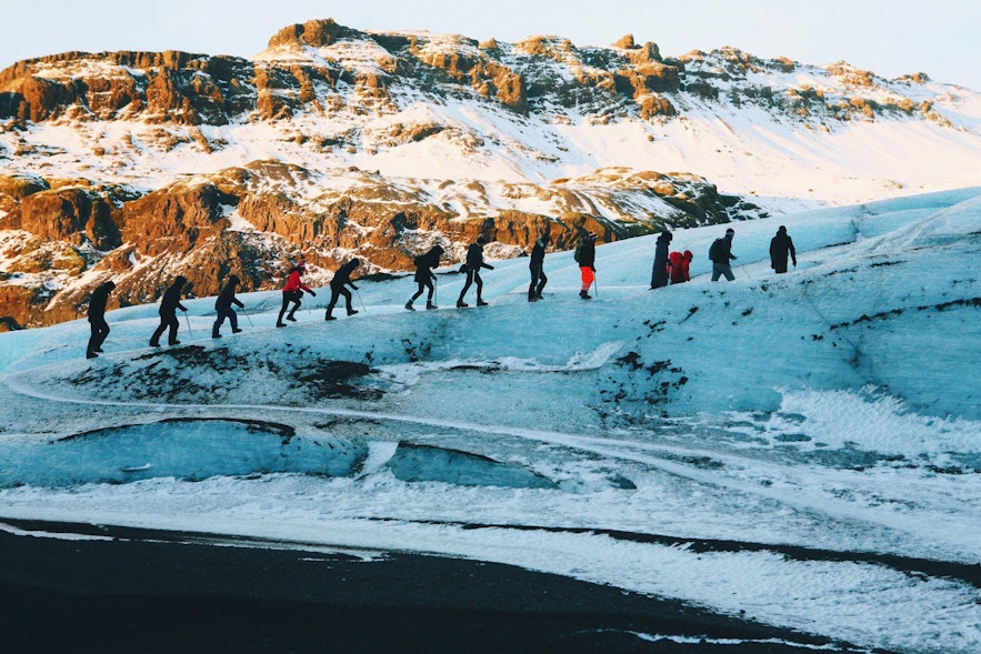 A line of customers follow their guide up Solheimajökull.