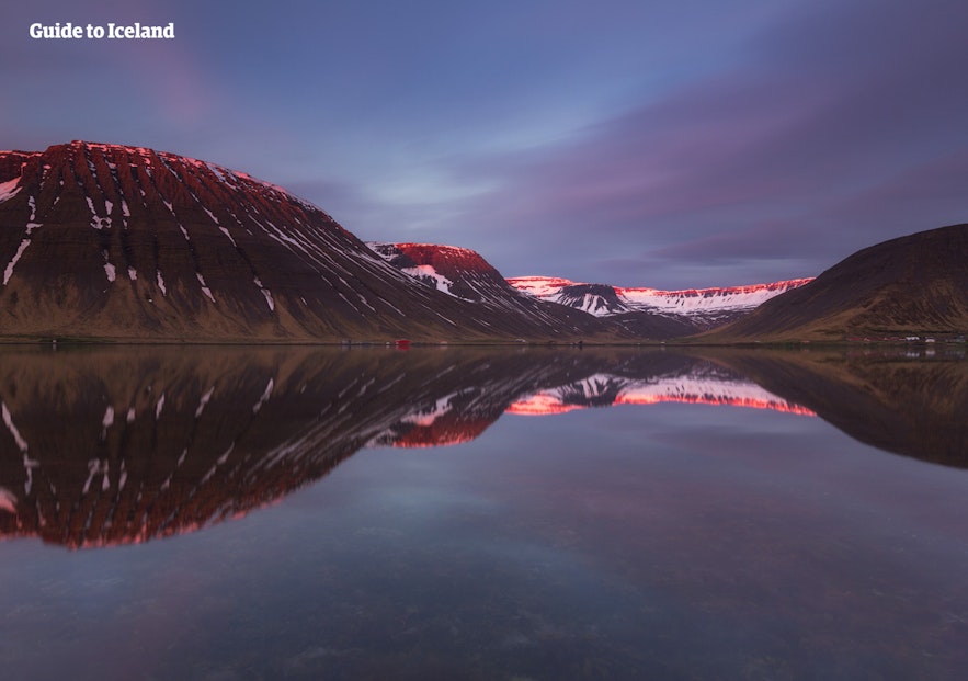 Isafjordur's snow-dusted mountains and twilight sky reflects the Westfjords.