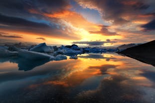 De kleurrijke lucht weerspiegelt perfect op het stille oppervlak van het diepste meer van IJsland, de gletsjerlagune Jökulsárlón.