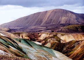 Landmannalaugar in the Icelandic Highlands is known for its striking rainbow-colored rhyolite mountains, streaked with shades of yellow, red, green, pink, and blue.