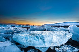 Kimmeltävää jäätä Timanttirannan mustalla hiekalla lähellä Jökulsárlónin jäätikköjärveä.