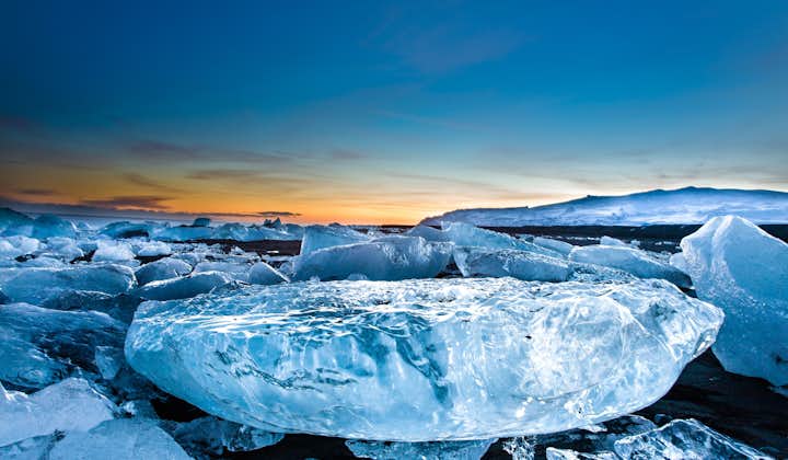 Spegelblank is täcker den svarta sandstranden på Diamantstranden nära issjön Jökulsárlón.