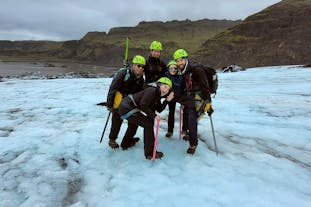 A group of adventurers posing atop the Solheimajokull glacier in Iceland.