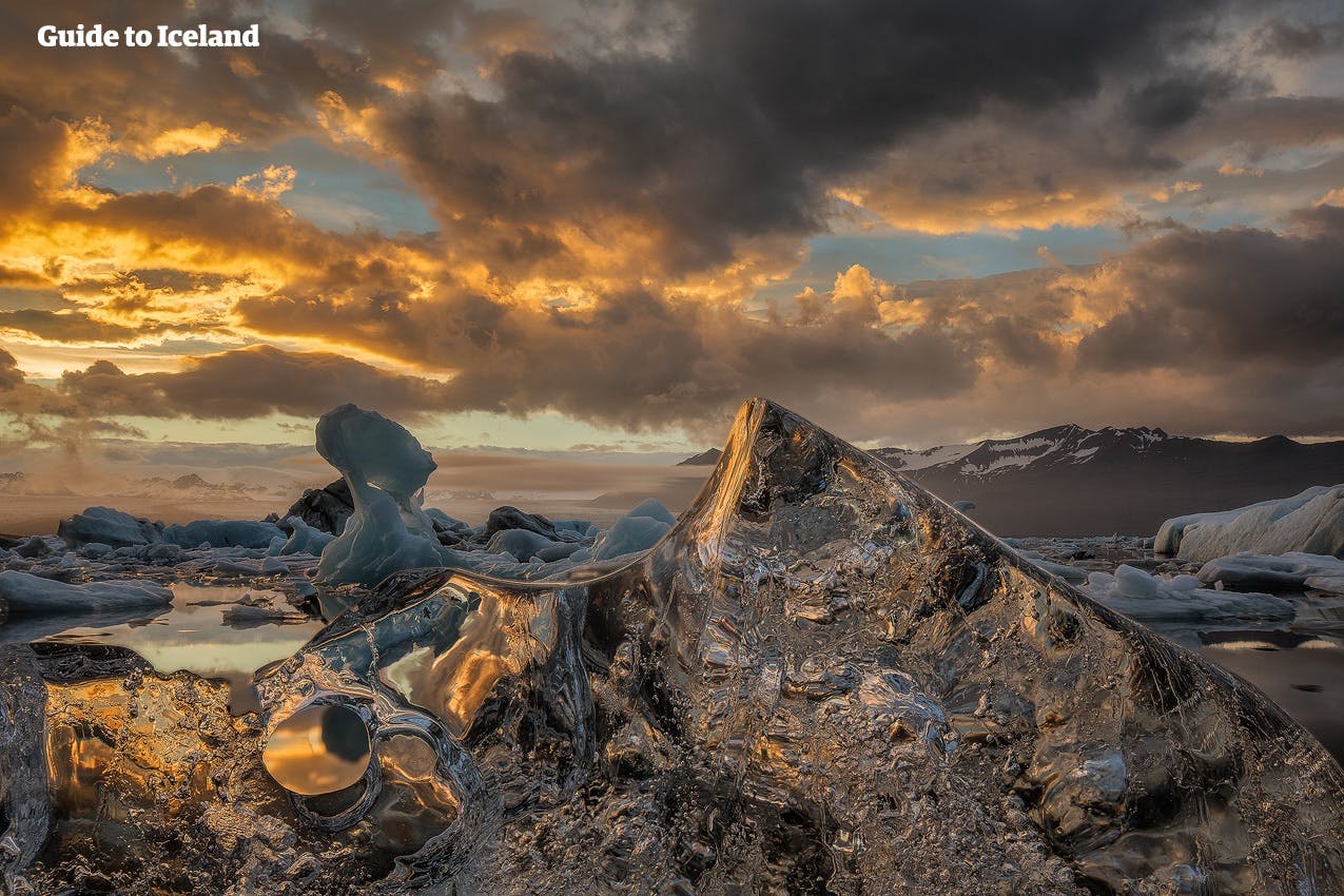 De gouden gloed van de winterzon verlicht de gletsjerlagune van Jökulsárlón terwijl kristalheldere ijsbergen sereen op het water dobberen