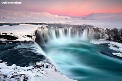 Der 30 Meter breite Goðafoss-Wasserfall, der im Winter über gefrorene Klippen hinabstürzt