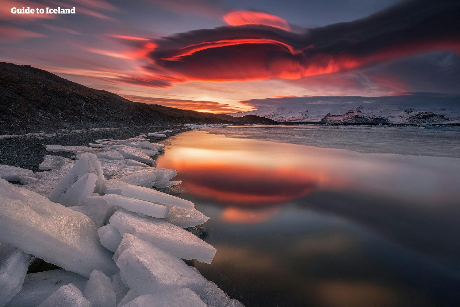 Solen går ned over bresjøen Jökulsárlón og maler himmelen rød