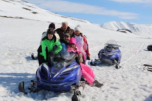 A family pose for a picture on a snowmobile during a tour in Iceland.