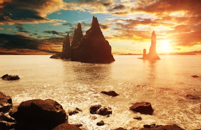 Summer sunset at the rock promontories of Reynisdrangar, on Iceland's South Coast.