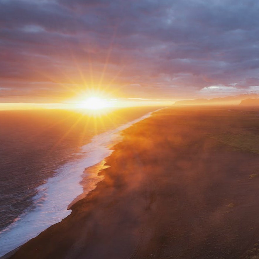 冰岛南岸迪霍拉里海岬山顶鸟瞰黑沙滩日落