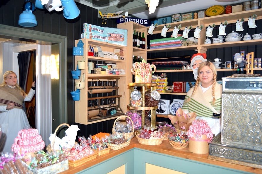 В рождественском магазине продается множество различных сладостей и работают сотрудницы в традиционных нарядах