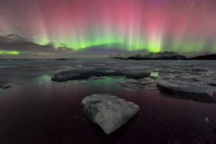 La aurora boreal brilla sobre la laguna glaciar de Jokulsarlon.