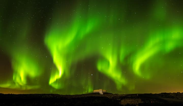 Snakes of the aurora borealis wind across the starry skies of Reykjavík.