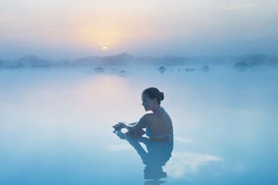 Eine Person entspannt sich in den heilenden Gewässern des Geothermal-Spas Blaue Lagune.