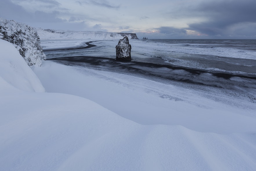 雪のレイニスフィヤラの黒砂海岸。冬は波が特に荒いので注意したい。