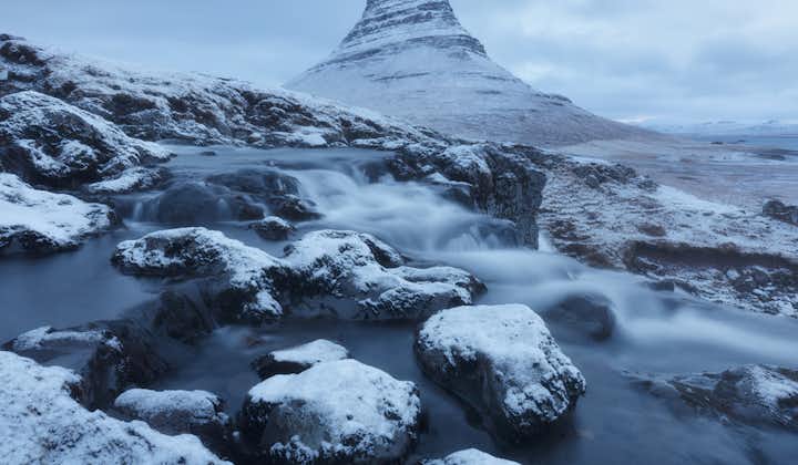 El Monte Kirkjufell, de pie junto a la península de Snæfellsnes, adquiere un aspecto llamativo cubierto de nieve durante el invierno islandés.