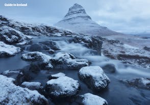 El Monte Kirkjufell, de pie junto a la península de Snæfellsnes, adquiere un aspecto llamativo cubierto de nieve durante el invierno islandés.