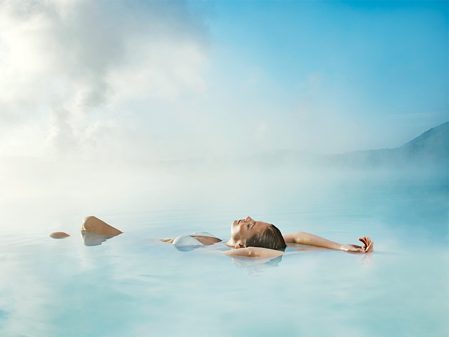 Eine Frau entspannt sich in den Gewässern der Blauen Lagune