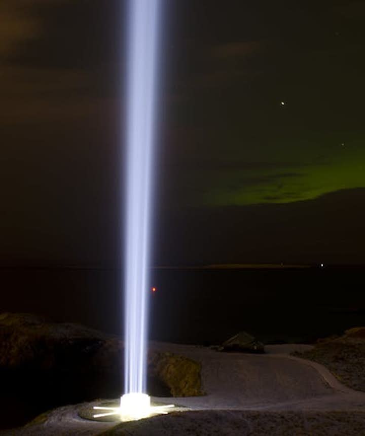 The Imagine Peace Tower, lit against the night sky