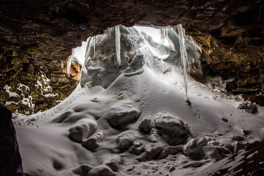 Schnee ergießt sich in eine eisige Lavahöhle
