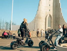 A group of people riding e-scooters in front of the Hallgrimskirkja church in Reykjavik.