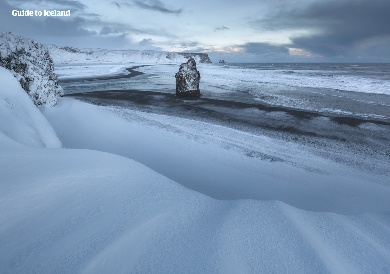 冰岛南岸黑沙滩的墨黑火山沙砾在冬季都被厚重的白雪覆盖