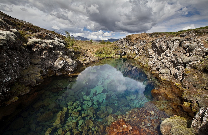 Near the entrance to Silfra Fissure, guests can look down into the crystal clear glacial water.