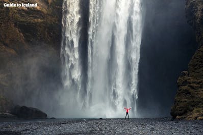 La tierra debajo de la cascada Skógafoss en la Costa Sur es muy plana, por lo que puedes caminar hasta la pared de agua