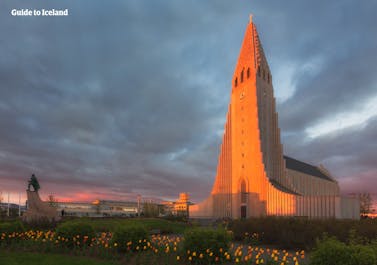 De majestueuze Hallgrímskirkja-kerk in Reykjavík baadt in de warme gloed van de middernachtzon