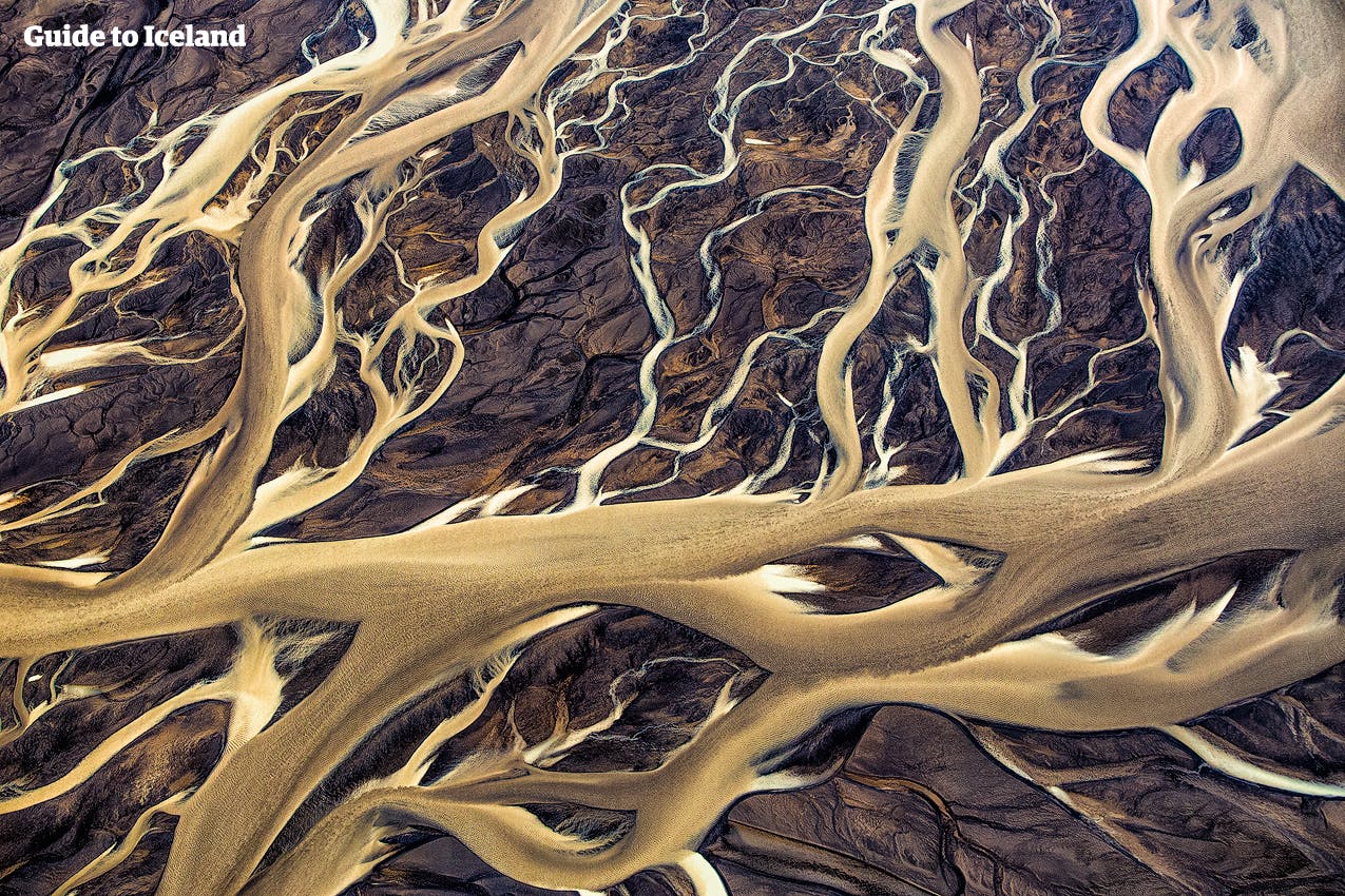 River systems wind across black sand deserts in the Icelandic Highlands.