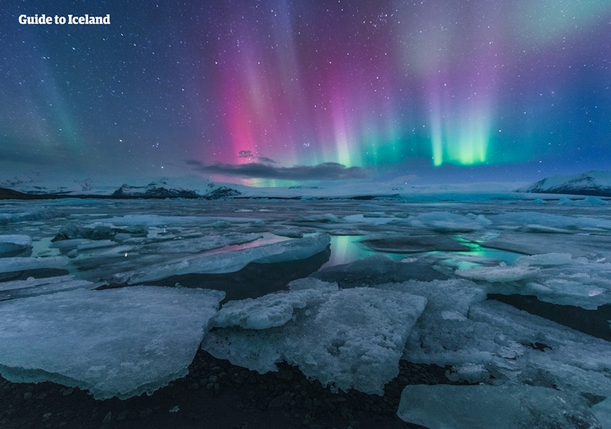 The Northern Lights dancing in purple, pink, and green colours over Jökulsárlón Glacier Lagoon