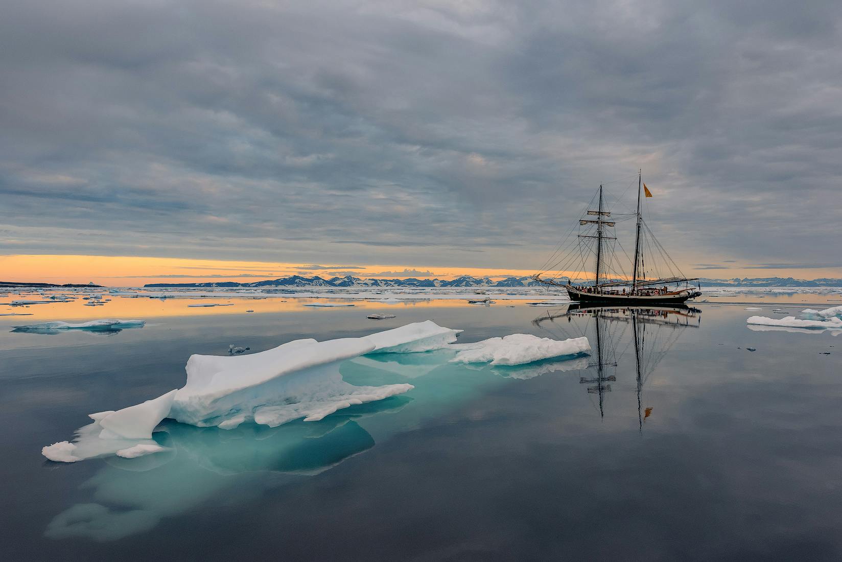 唐娜木船静静地驶过格陵兰岛海岸的冰山