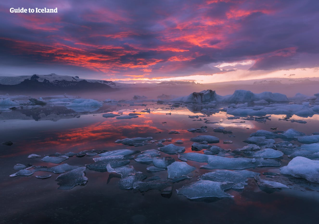 Se titaniske isfjell flyte fredelig på en rolig innsjø i Jökulsárlón isbrelagune.
